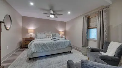 a bedroom with a bed and a chair and a window at The Suite in a historic carriage house in Kennett Square