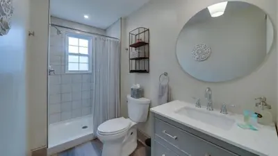 a bathroom with a toilet and a sink and a mirror at The Suite in a historic carriage house in Kennett Square