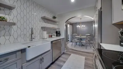 a kitchen with white counters and a dining room at The Suite in a historic carriage house in Kennett Square
