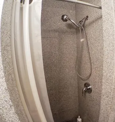a shower with a shower curtain and a shower head at Studios in New York in New York