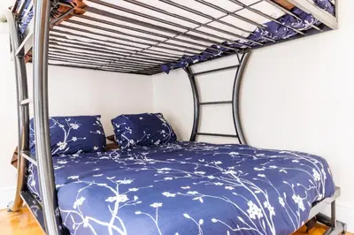 a bedroom with a bunk bed with a blue bedspread at Studios in New York in New York