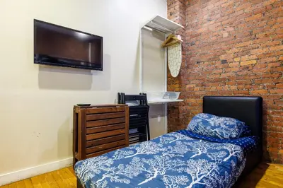 a bedroom with a bed and a brick wall at Studios in New York in New York