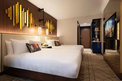 a hotel room with a large white bed and chandeliers at Hard Rock Hotel New York in New York