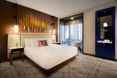 a bedroom with a large white bed and a desk at Hard Rock Hotel New York in New York