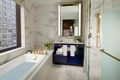 a bathroom with a tub and a sink and a mirror at Hard Rock Hotel New York in New York