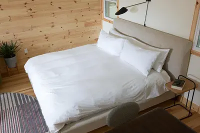 a bed with white sheets and pillows in a room at The Rex in Greentown