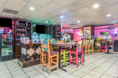 a restaurant with a table and colorful chairs at Quality Inn & Suites York East in York