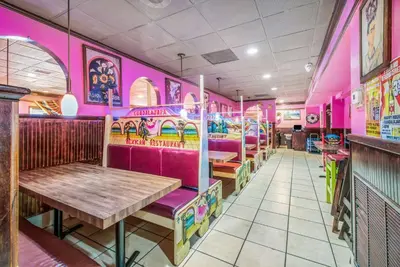a restaurant with pink walls and a wooden table at Quality Inn & Suites York East in York