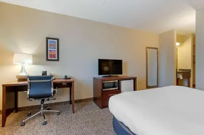 a hotel room with a bed and a desk and a television at Comfort Inn Mechanicsburg - Harrisburg South in Mechanicsburg