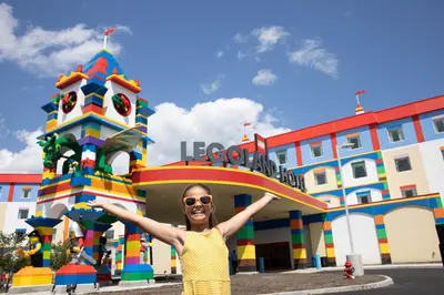 a woman is standing in front of a building at LEGOLAND New York Resort in Goshen