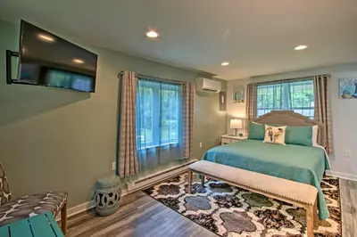 a bedroom with a bed and a tv and windows at 15 Mi to Camelback Resort! The Overlook Home in Brodheadsville
