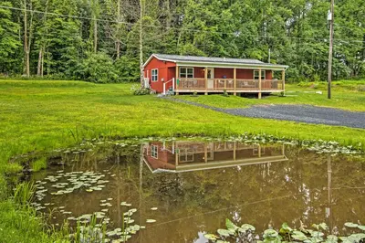 a red cabin with a pond in front of it at 15 Mi to Camelback Resort! The Overlook Home in Brodheadsville