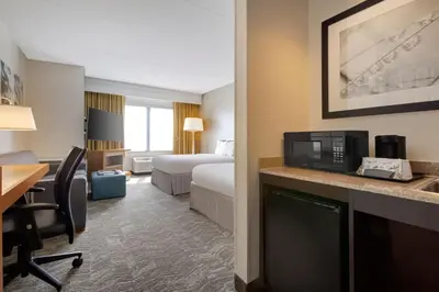 a hotel room with a bed and a desk with a microwave at SpringHill Suites by Marriott Newark International Airport in Newark