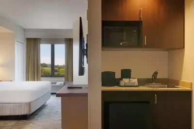 a hotel room with a bed and a kitchen with a sink at SpringHill Suites by Marriott Newark International Airport in Newark