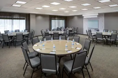 a conference room with tables and chairs in it at SpringHill Suites by Marriott Newark International Airport in Newark