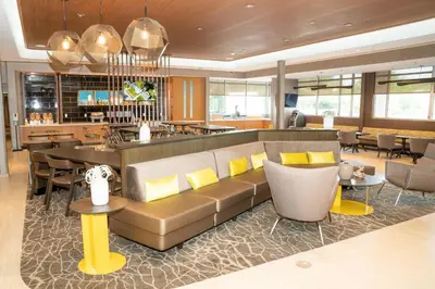 a living room with a couch and a bar at SpringHill Suites by Marriott Woodbridge in Woodbridge
