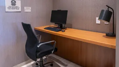 a desk with a computer monitor and a chair at SpringHill Suites by Marriott Woodbridge in Woodbridge