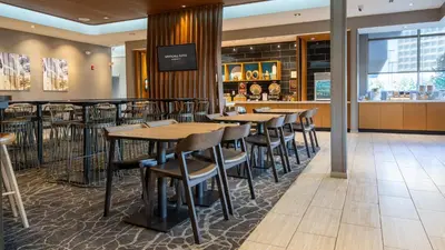 a restaurant with tables and chairs and a bar at SpringHill Suites by Marriott Woodbridge in Woodbridge