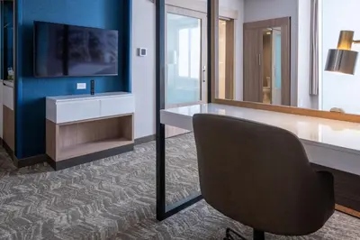 a room with a desk and a chair and a television at SpringHill Suites by Marriott Woodbridge in Woodbridge
