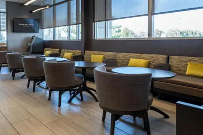 a dining room with tables and chairs and windows at SpringHill Suites by Marriott Woodbridge in Woodbridge