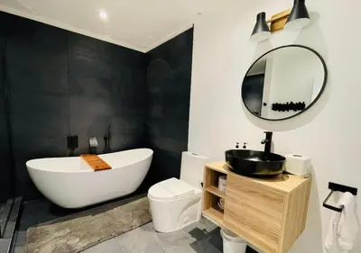 a bathroom with a tub and a sink and a mirror at Scandi Lakefront Condo Near Big Boulder Ski! in Lake Harmony