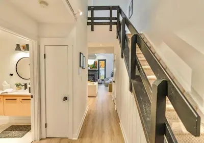 a hallway of a home with a staircase and a stair case at Scandi Lakefront Condo Near Big Boulder Ski! in Lake Harmony