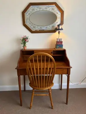 a wooden desk with a chair and a mirror at Country Inn of Hazlet in Hazlet