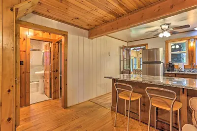 a kitchen with a counter and chairs in a room at Steps to Lake Tafton Cottage with Fire Pit and Grill in Tafton