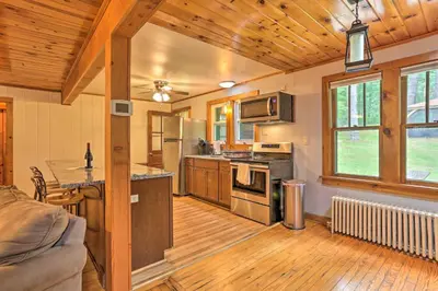 a large kitchen with wooden floors and a wooden ceiling at Steps to Lake Tafton Cottage with Fire Pit and Grill in Tafton