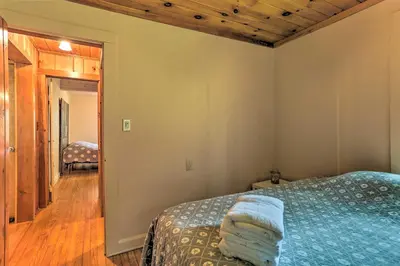 a bedroom with a bed and a hallway at Steps to Lake Tafton Cottage with Fire Pit and Grill in Tafton