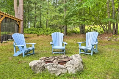 three blue chairs sitting next to a fire pit at Steps to Lake Tafton Cottage with Fire Pit and Grill in Tafton