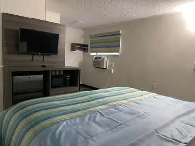 a bedroom with a bed and a flat screen tv at Crown Inn in Linden
