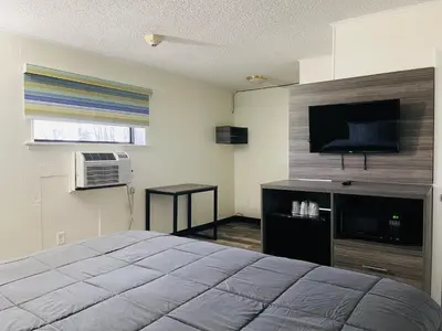 a bedroom with a bed and a flat screen tv at Crown Inn in Linden