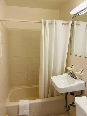 a bathroom with a sink and a tub and a shower curtain at Crown Inn in Linden