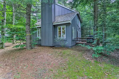 a small gray house in the middle of the woods at Unwind Fireside and Walk to Slopes! Poconos Getaway in Lake Harmony