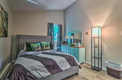 a bedroom with a bed and a dresser and a mirror at Fire Pit and Community Perks Blakeslee Cottage! in Blakeslee