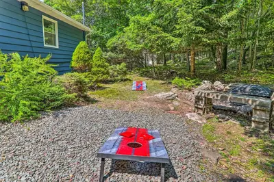 a picnic table with red flowers on it in a yard at Fire Pit and Community Perks Blakeslee Cottage! in Blakeslee