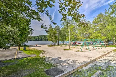 an empty park with a playground next to a lake at Fire Pit and Community Perks Blakeslee Cottage! in Blakeslee
