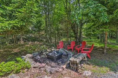 a group of red chairs sitting around a fire pit at Fire Pit and Community Perks Blakeslee Cottage! in Blakeslee