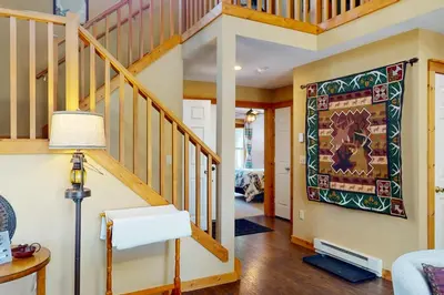a living room with a staircase and a painting on the wall at Northridge 372 in Tannersville