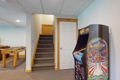 a room with a pinball machine next to a staircase at Northridge 372 in Tannersville