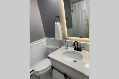 a bathroom with a sink and a toilet and a mirror at Just renovated Camelback SKI-ON/OFF,SNOW TUBING,PAINTBALL in Tannersville
