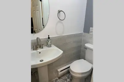 a bathroom with a sink and a toilet and a mirror at Just renovated Camelback SKI-ON/OFF,SNOW TUBING,PAINTBALL in Tannersville