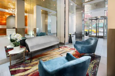 a lobby with two blue chairs and a rug at OYO Times Square in New York