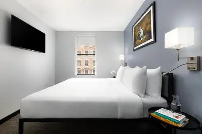 a bedroom with a large white bed and a window at OYO Times Square in New York