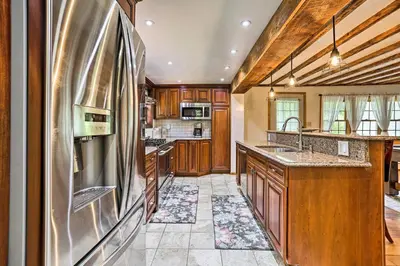 a kitchen with wooden cabinets and a stainless steel refrigerator at Game Room and Yard Greentown Home Near State Park in Greentown