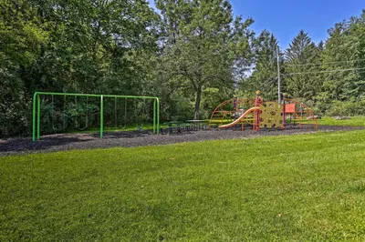 a playground in a park with a grass field at Deck and Gas Grill Modern East Stroudsburg Home! in East Stroudsburg