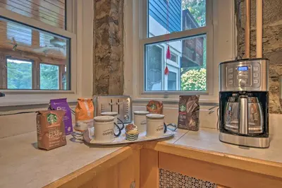 a counter with coffee cups and a coffee maker on it at Lakefront Poconos Retreat with Hot Tub, Near Hiking! in Bear Creek Village