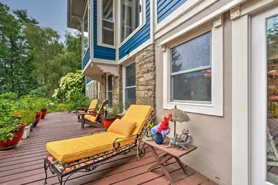 a porch with a yellow bench on a house at Lakefront Poconos Retreat with Hot Tub, Near Hiking! in Bear Creek Village