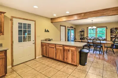 a kitchen with a counter and a dining room at Steps to River Big Bass Lake House with Grill! in Gouldsboro